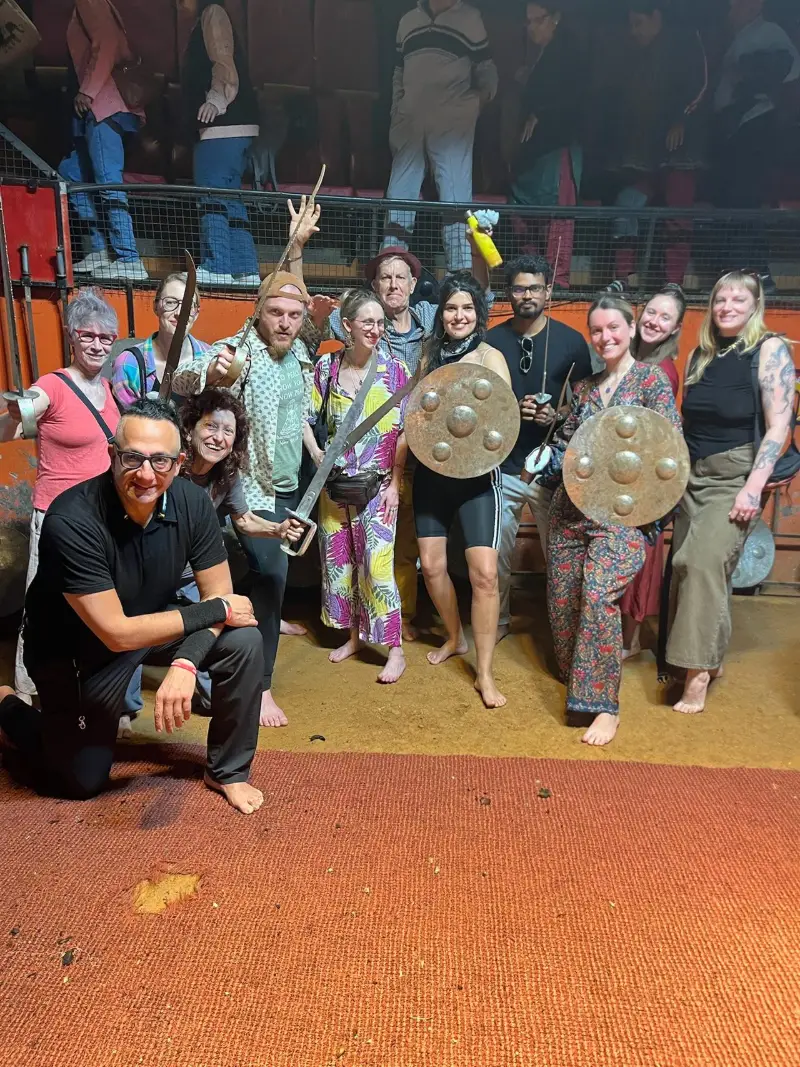 Students posing with traditional swords and shields after a cultural performance