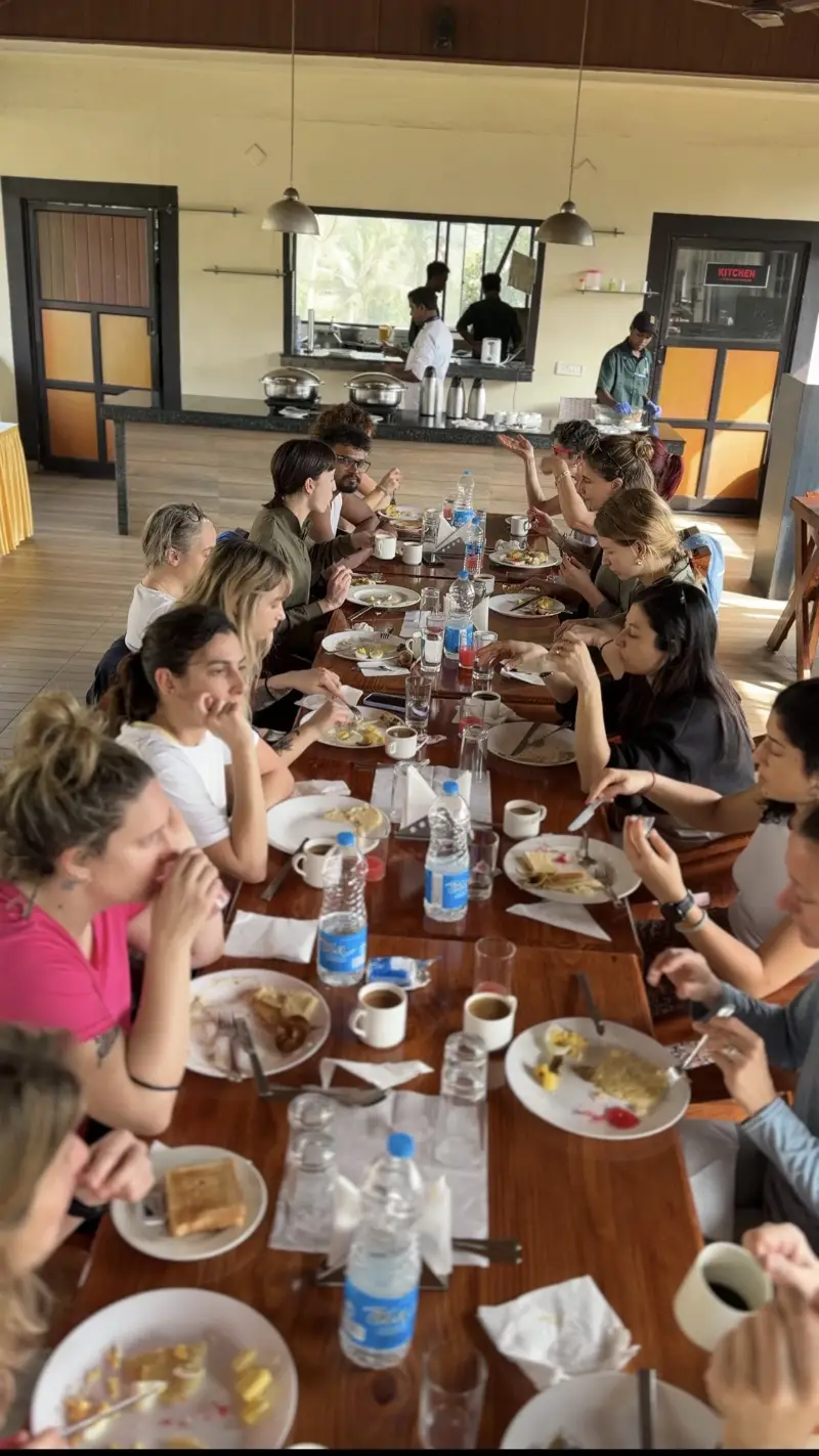 Students sharing a vegetarian meal around a long wooden table
